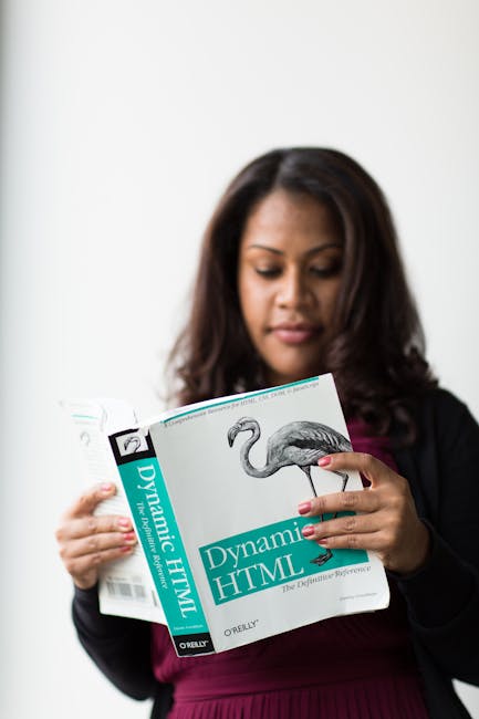 There is no image related to gardening, landscaping, or outdoor maintenance present. The photo shows a woman with dark hair reading a book titled 'Dynamic HTML' by O'Reilly, holding the book with both